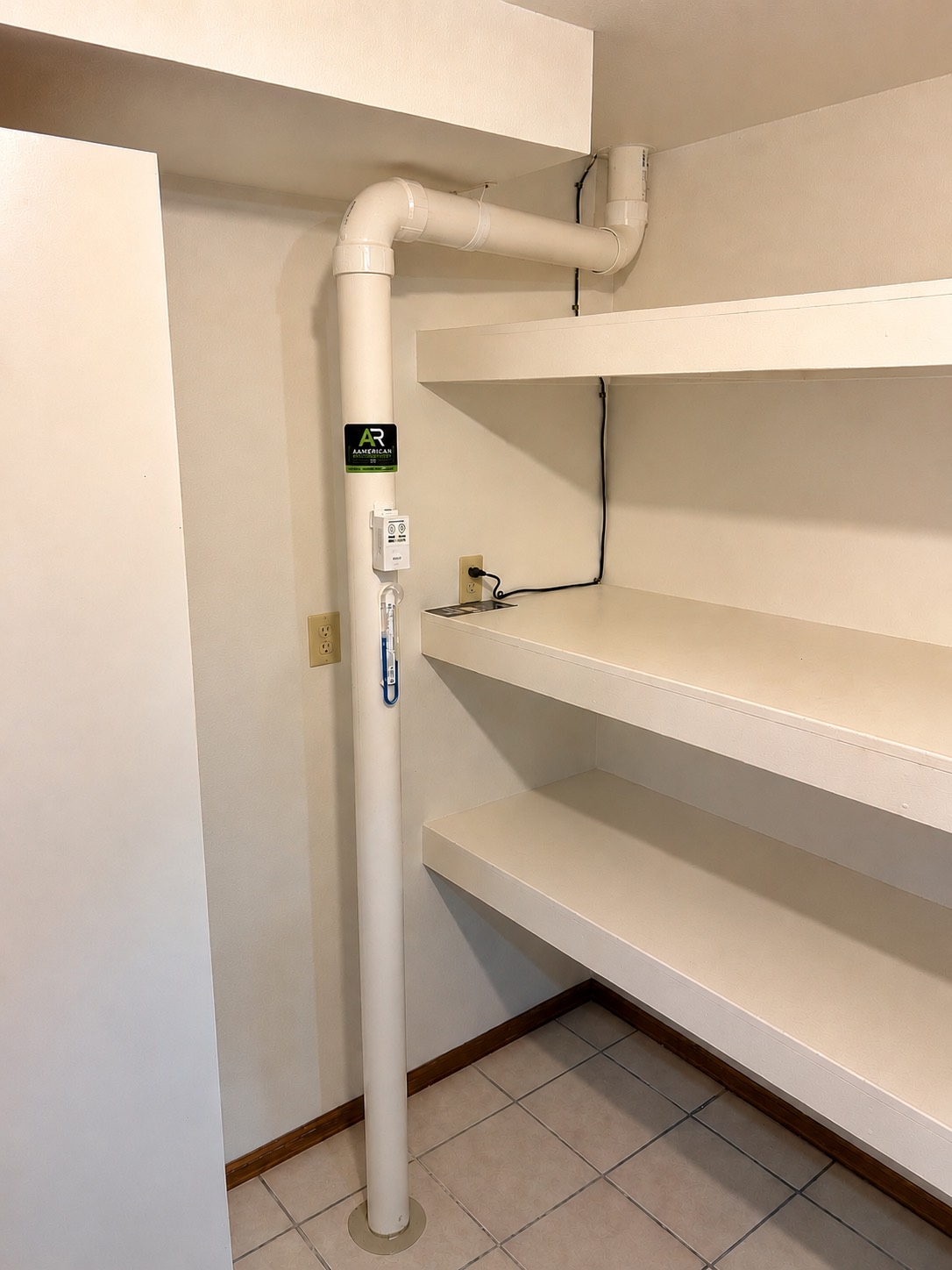 Radon mitigation pipe routed neatly up the corner of a pantry closet, keeping the run out of the living space